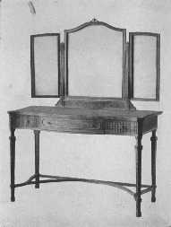 The modern style of mirror is brought into harmony with
the eighteenth century dressing-table by means of carving.